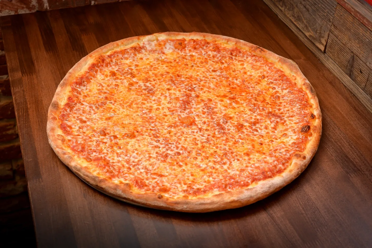 A pizza sitting on top of a wooden table.