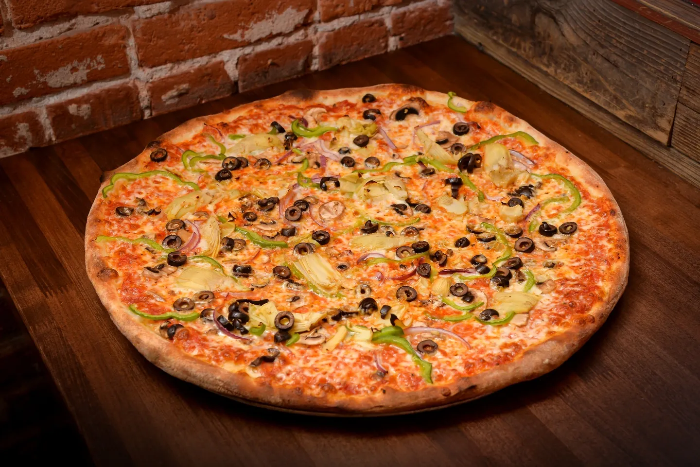 A pizza sitting on top of a wooden table.