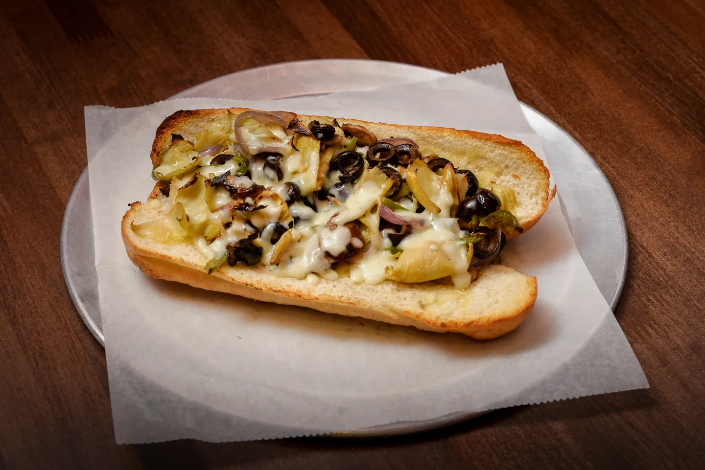 A sandwich with potatoes and olives on it.