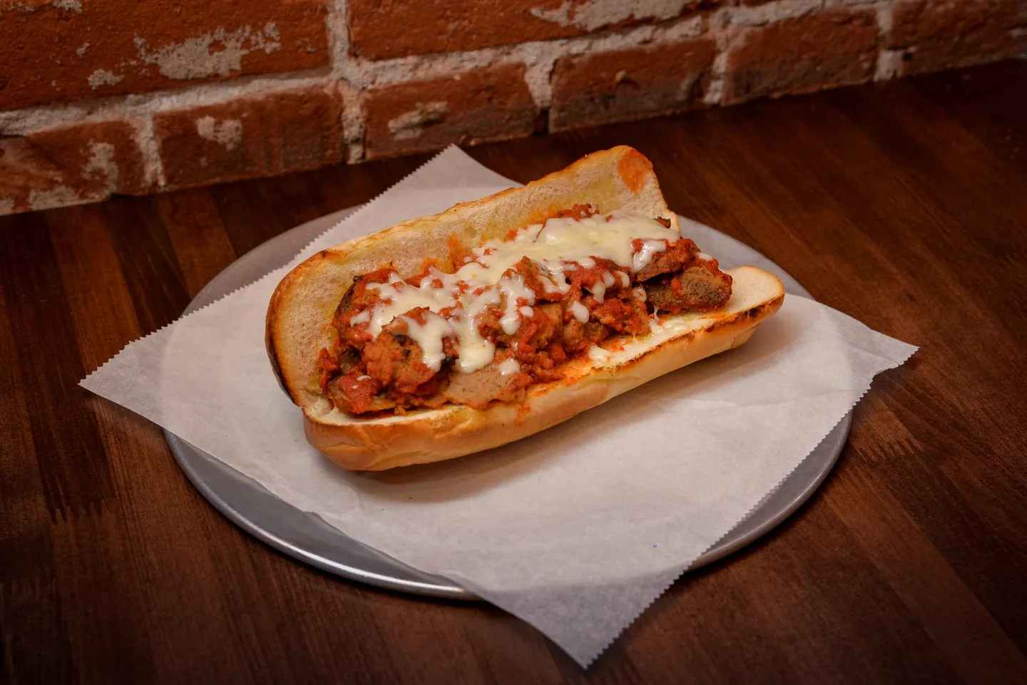 A meatball sub sandwich on top of a bun.