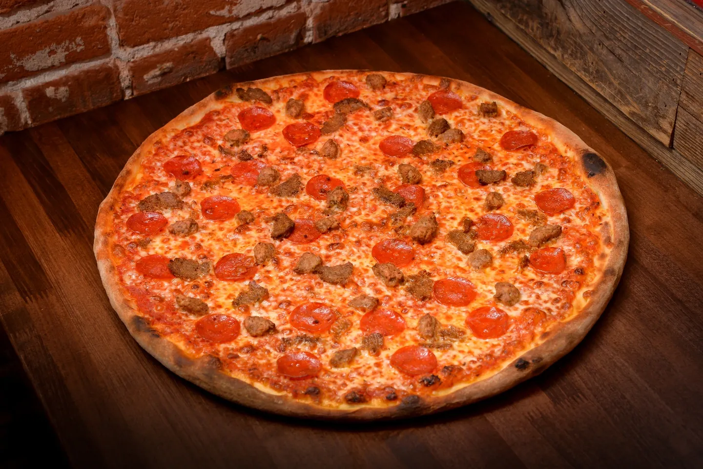 A pizza sitting on top of a wooden table.